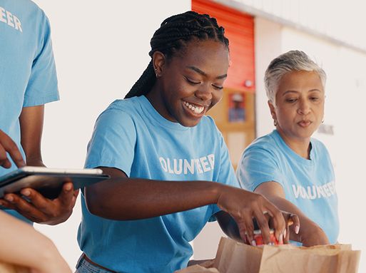 Three volunteers handing out food