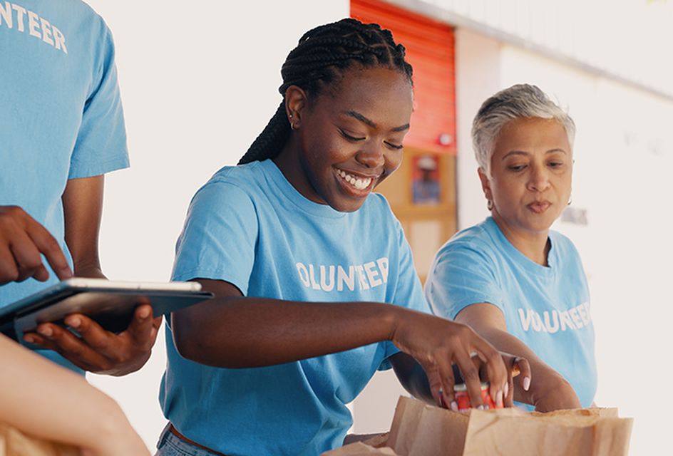 Three volunteers handing out food