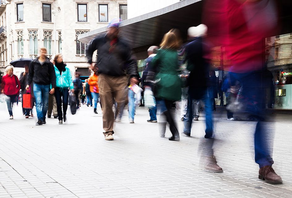 A blurry shot of people walking down a high street.