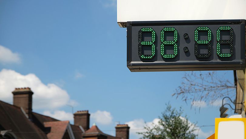 An LED sign in a street that reads "38°C".