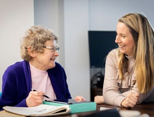 An elderly woman and a younger woman talking