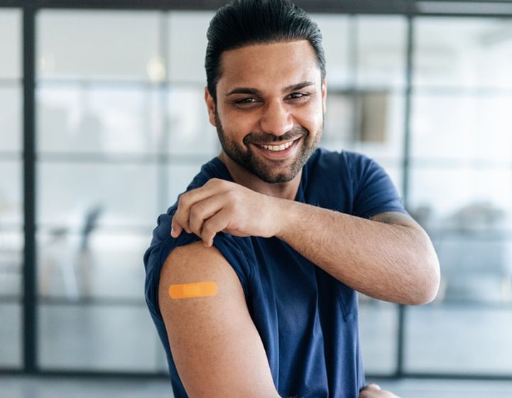 Man showing off a paster after getting vaccinated